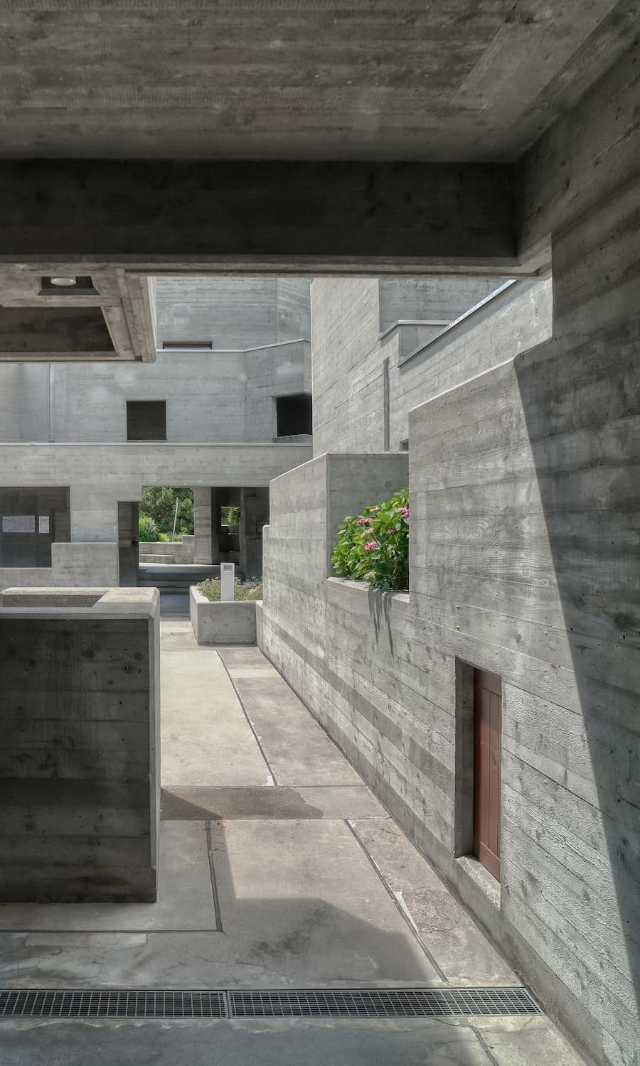 Layered concrete volumes receding into a covered interior.
