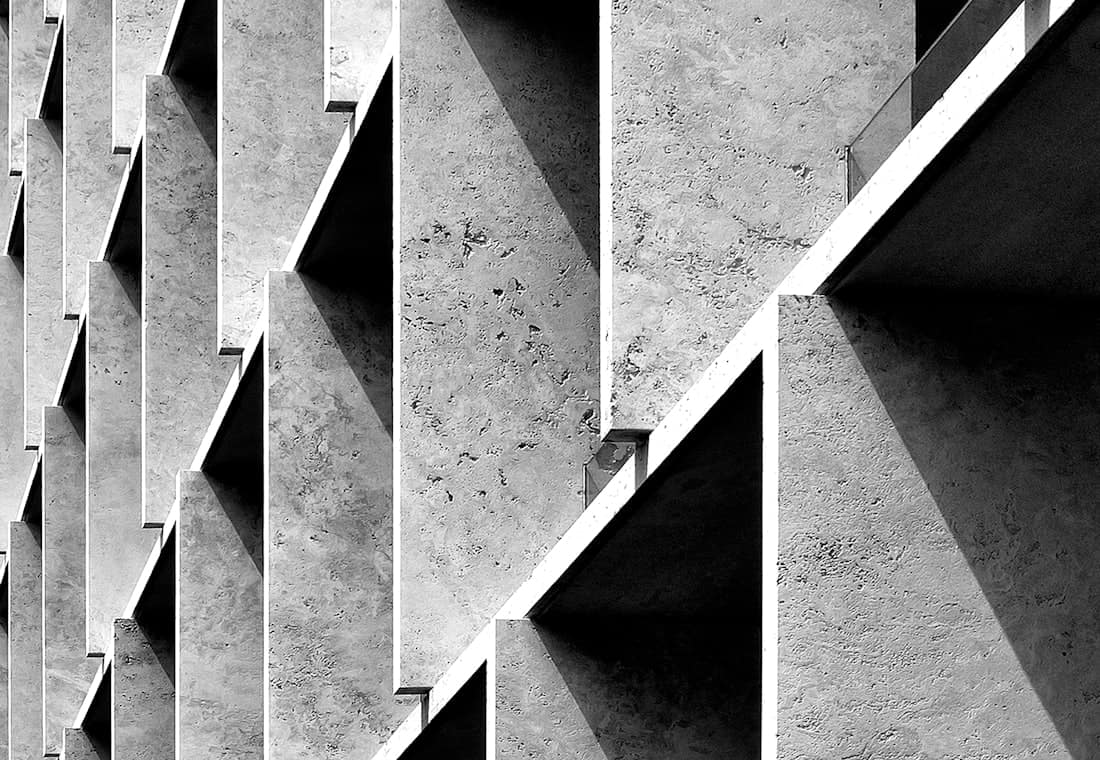 Oblique view of a concrete facade, its angled fins repeating across the frame.